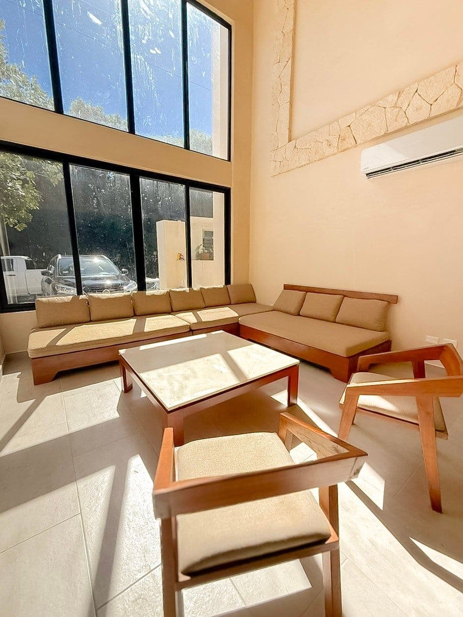 Living room of a villa at Villas Corax Tulum, with a floor-to-ceiling window