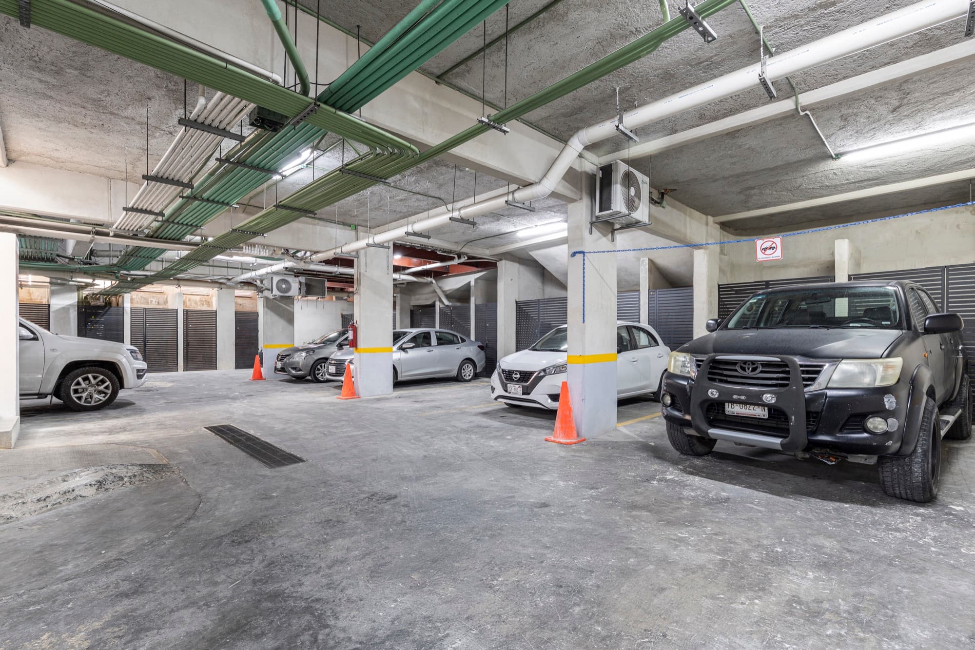 Estacionamiento subterráneo del edificio con autos estacionados