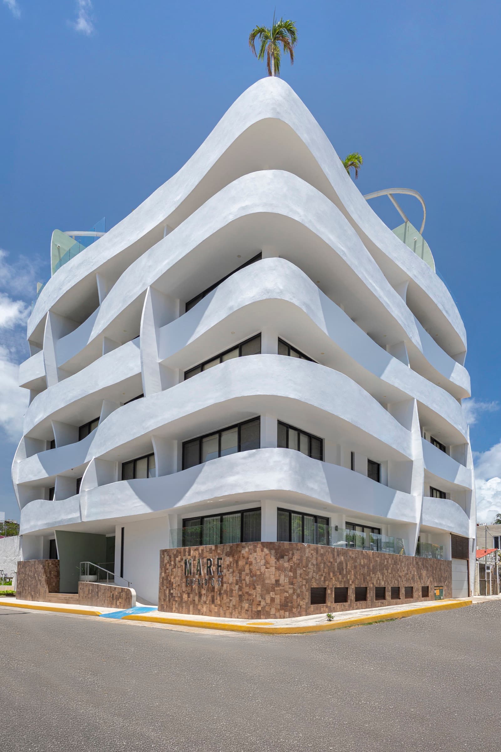 Mare Condo’s white, curved facade on a street corner